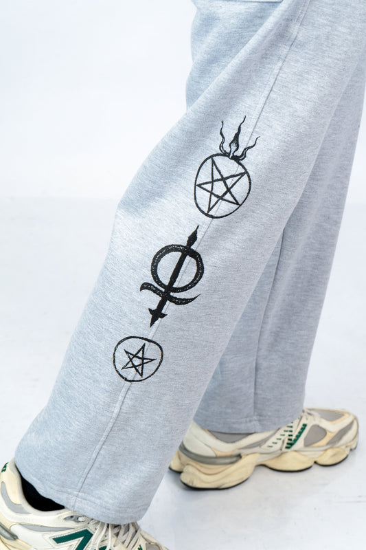 a person wearing a pair of sweatpants with a pen and a pentagramil