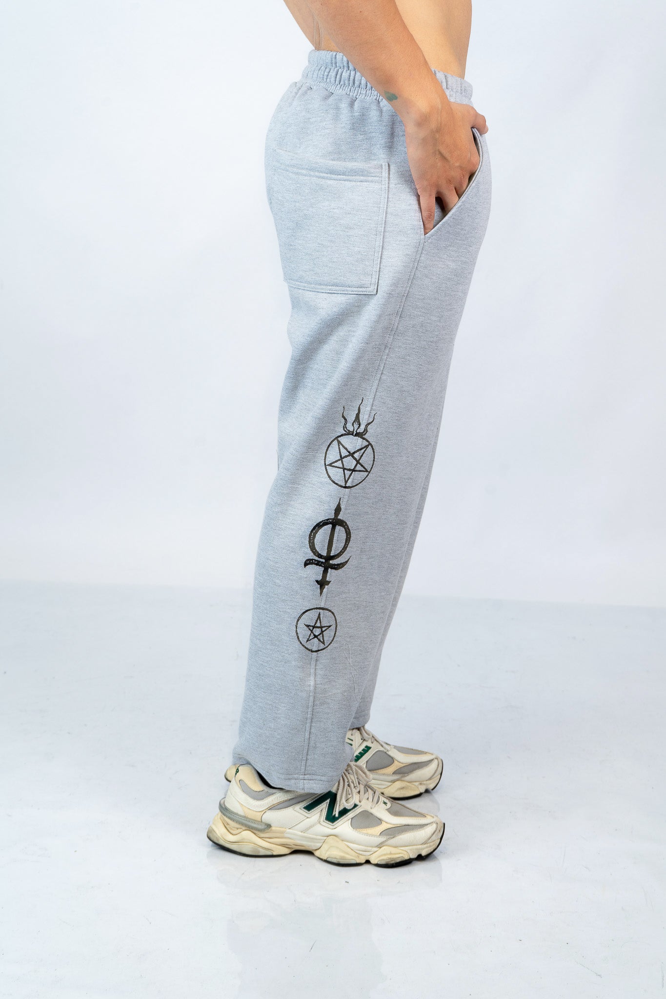 a man wearing a pair of grey sweatpants with symbols on them